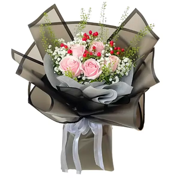 Pink roses, baby's breath, and red berries in a black paper bouquet with a white ribbon.