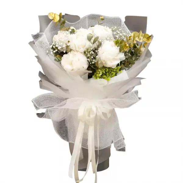 White peonies and greenery in a bouquet with white sheer wrapping and ribbon.