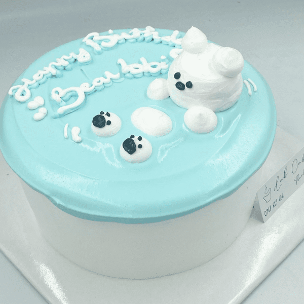 Blue cake with white frosting bear and "Happy Birthday" text.