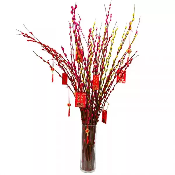 A vase of red and yellow pussy willow branches with red decorative tags and tassels.