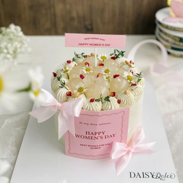 Cream cake decorated with lychee, daisy flowers, and pink ribbon.