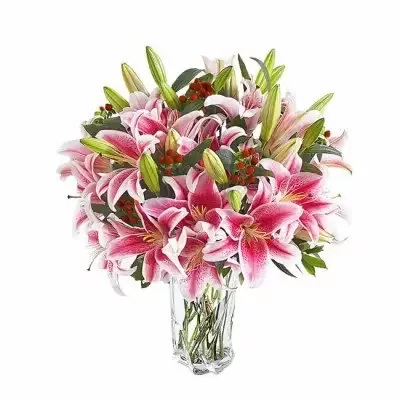 Bouquet of pink lilies and red berries in a clear glass vase.