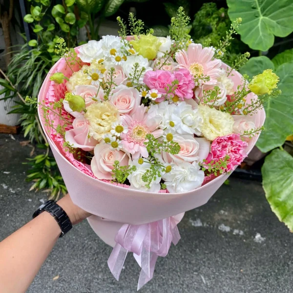 Pink and white rose bouquet with carnations, daisies, and greenery.