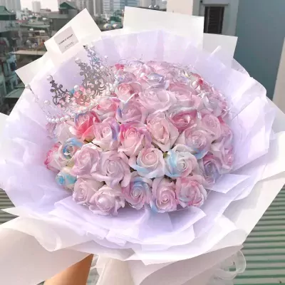 Multicolor roses and a silver crown in a white bouquet.