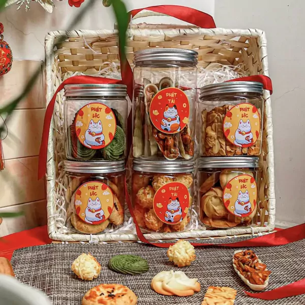 Gift basket filled with cookies and snacks, decorated with lucky cat motifs.
