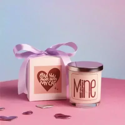 Gift box with purple ribbon and scented candle labeled "Mine".