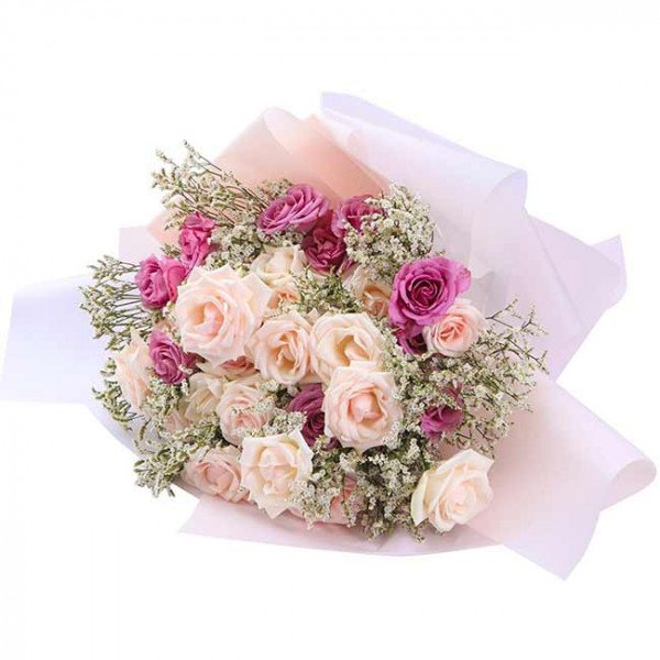 Bouquet of light pink and deep pink roses with white filler flowers, wrapped in pale pink and white paper.