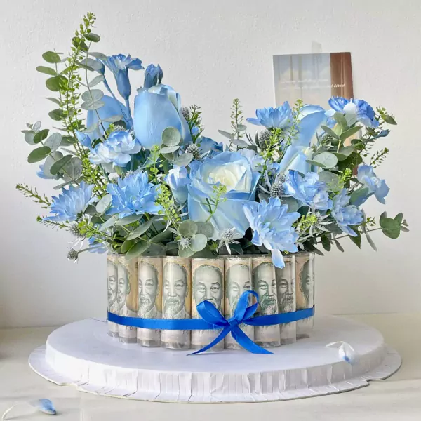 Blue flower arrangement with rolled banknotes around the base, tied with a blue ribbon.
