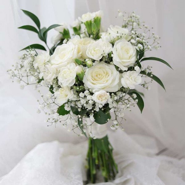 White bridal bouquet with roses, carnations, and baby's breath.