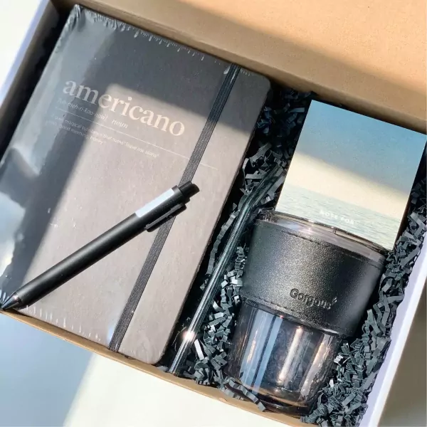 Impresso Americano gift set with notebook, pen, tumbler, and straw.