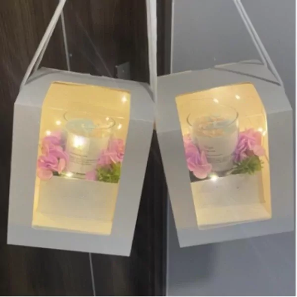 Scented candle gift box with pink flowers and fairy lights.