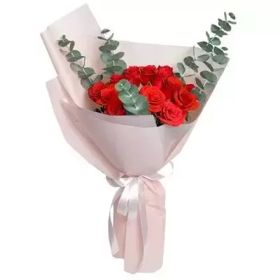 Bouquet of red roses and eucalyptus in pink paper with a white ribbon.