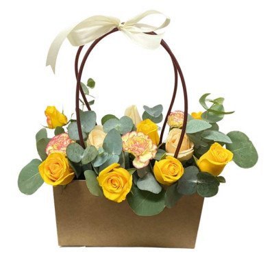 Yellow and pink roses and carnations in a brown basket with a ribbon bow.