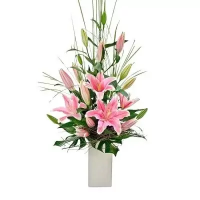 Pink lilies and greenery in a white vase.