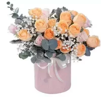 Pink box with peach and pink roses and baby's breath, decorated with a white ribbon.
