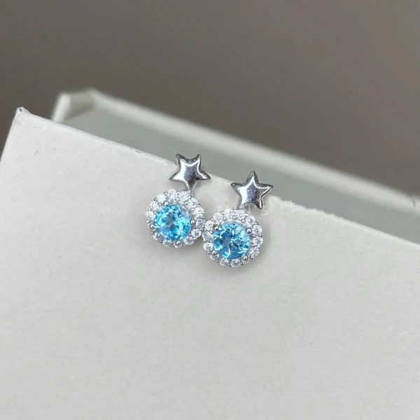 Starlight blue topaz stud earrings with small silver stars.