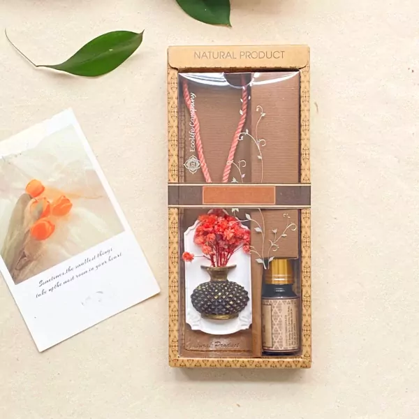 Gift set with a pink dreamcatcher, a flower-shaped diffuser, and essential oil.