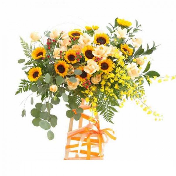Sunflower arrangement with yellow roses, red berries, and orchids in a basket with orange ribbon.