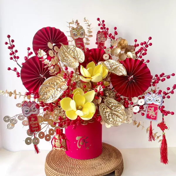 Red and gold floral arrangement with lucky charms, coins, and lion dancers.
