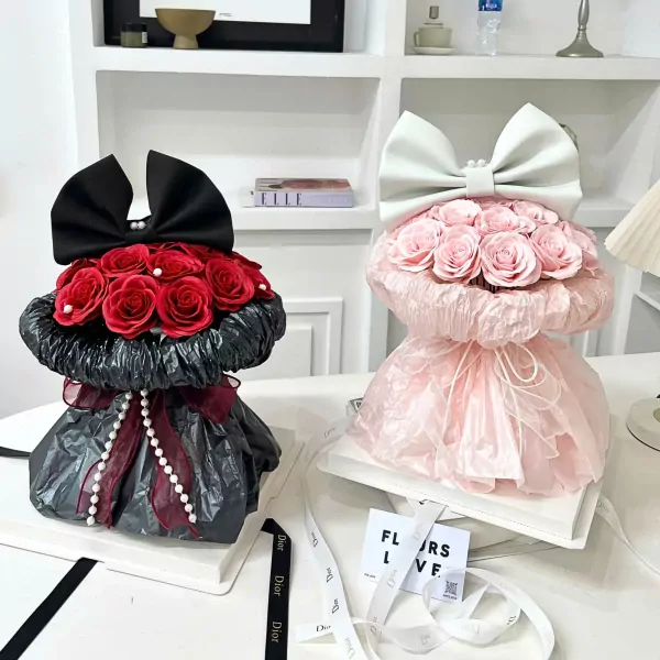Two bunny-shaped floral bouquets, one black with red roses, the other pink with pink roses.
