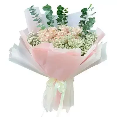 A bouquet of pale pink roses, baby's breath, and eucalyptus leaves, wrapped in pink and white paper with a ribbon bow.