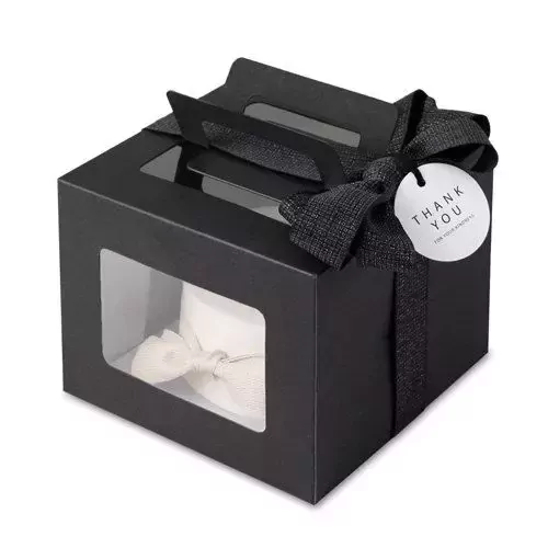 Black gift box with windows, ribbon, and "Thank You" tag, containing a white cake with a cream bow.
