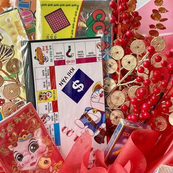 Monopoly board with Doraemon, gold coins, and red berries in a bouquet.