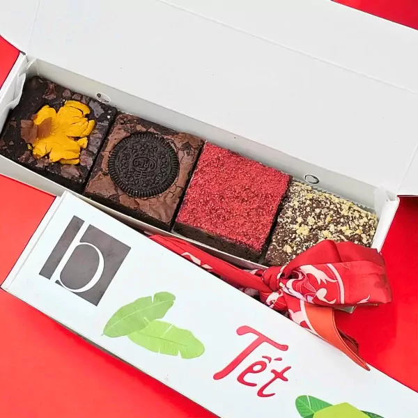 Brownies with Oreo, red sprinkles, and nuts in a Tet gift box with a red scarf.