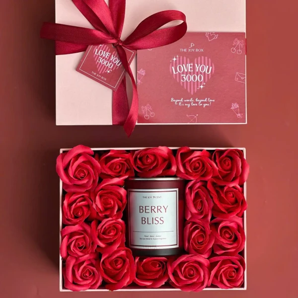 Gift box with red roses and a "Berry Bliss" candle, tied with a red ribbon.