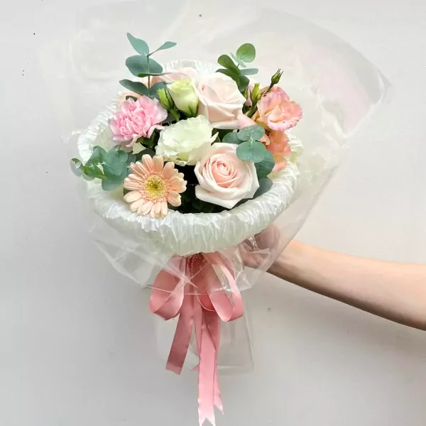 Pink and white floral bouquet with roses, carnations, gerbera daisies, and eucalyptus.