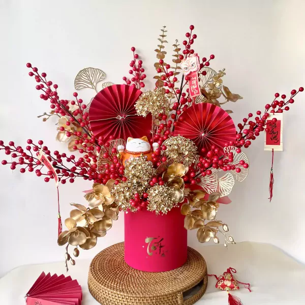 Pink floral box with red berries, gold leaves, and a lucky cat.