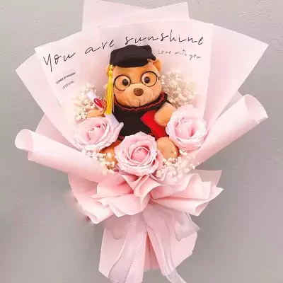 Graduation bear bouquet with pink roses and baby's breath.