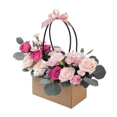 Box arrangement of pink and cream roses with carnations and eucalyptus.
