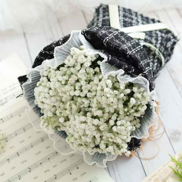 White baby's breath bouquet wrapped in black and white tweed with lace trim.