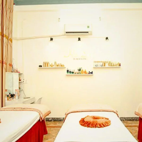 Massage beds and shelves with beauty products in a spa room.