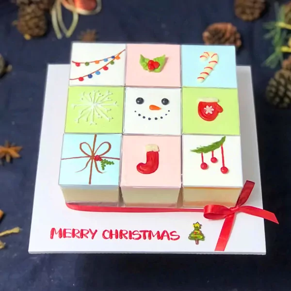Christmas mousse cake set with festive decorations on top and "Merry Christmas" text.