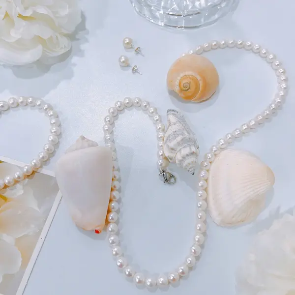 Pearl necklace on an open book with two loose pearls nearby.