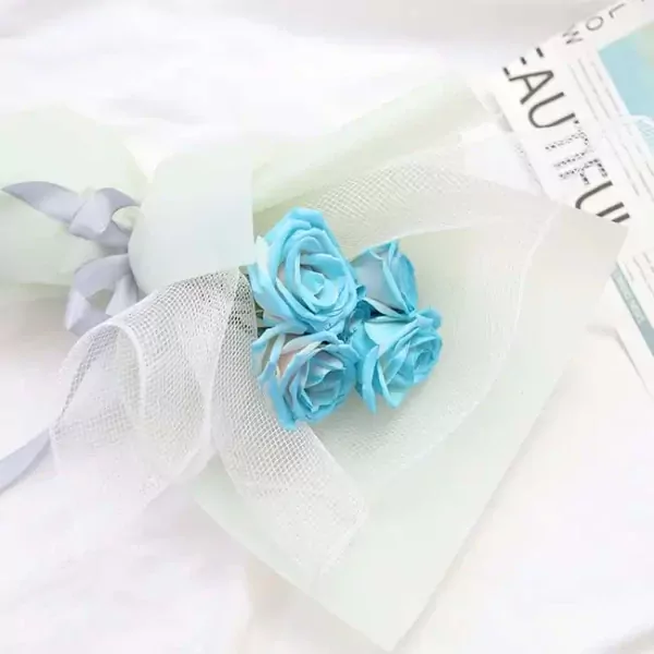 Bouquet of four light blue artificial roses with white mesh and a grey ribbon.