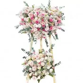 Two-tiered floral arrangement with pink and white roses, daisies, and greenery.