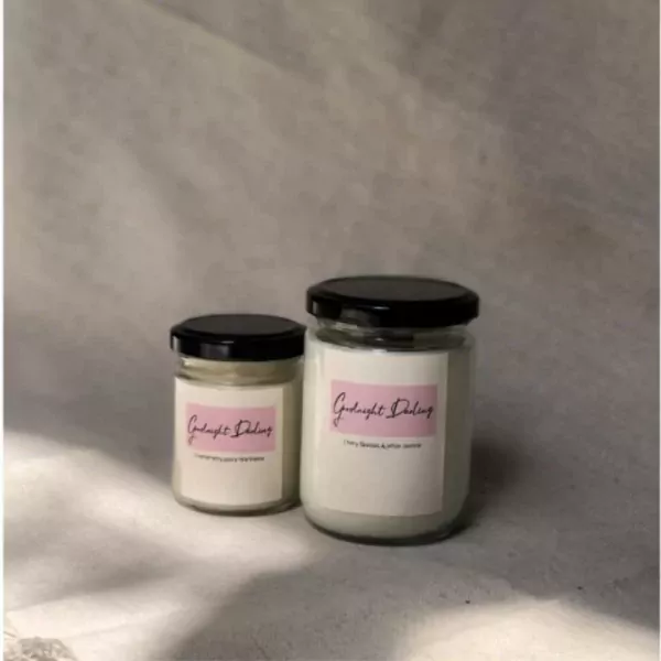 Two glass candles with black lids and pink labels saying "Goodnight Darling".