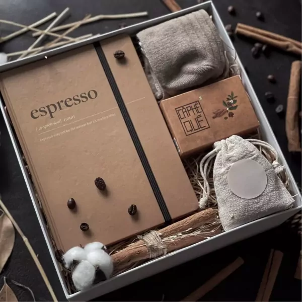 Espressiano gift set with notebook, socks, coffee beans, cinnamon sticks, and cotton.