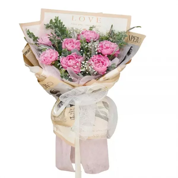 Pink peonies, baby's breath, and eucalyptus in newspaper-style wrapping with a white ribbon.