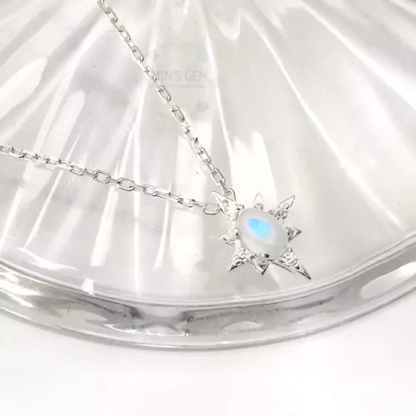Silver star necklace with an oval moonstone pendant.