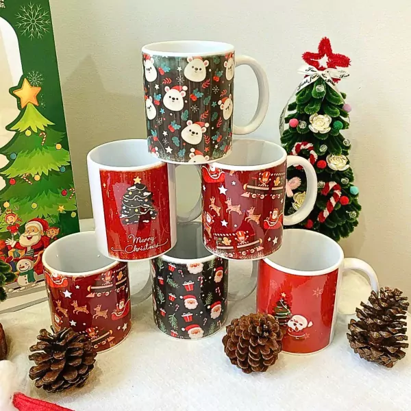 Christmas mugs with festive designs and a mini Christmas tree.