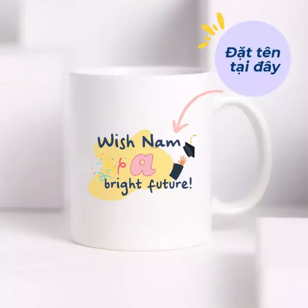 White ceramic mug with graduation-themed design and "Đặt tên tại đây" text.