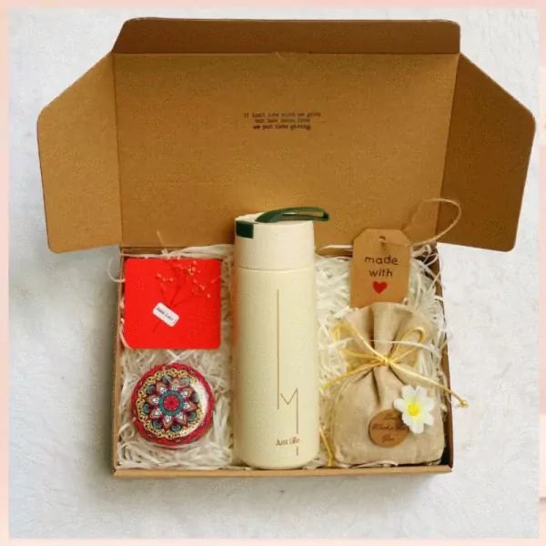 Gift box with thermal flask, handmade candle, small pouch, and card.
