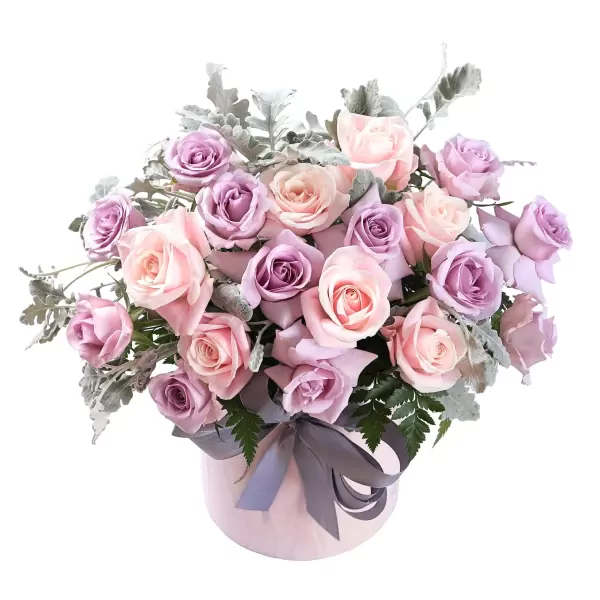Pink and purple roses in a light pink hatbox with a gray ribbon.
