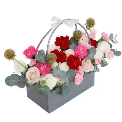 Floral arrangement in a grey rectangular basket with pink, white, and red flowers and green leaves.