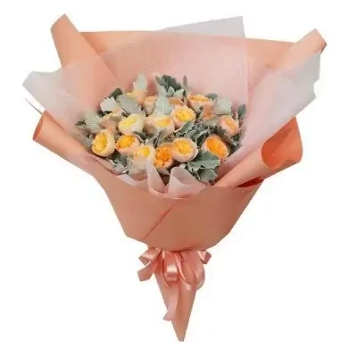 Bouquet of yellow and orange David Austin roses with dusty miller and purple star flowers, wrapped in peach paper.