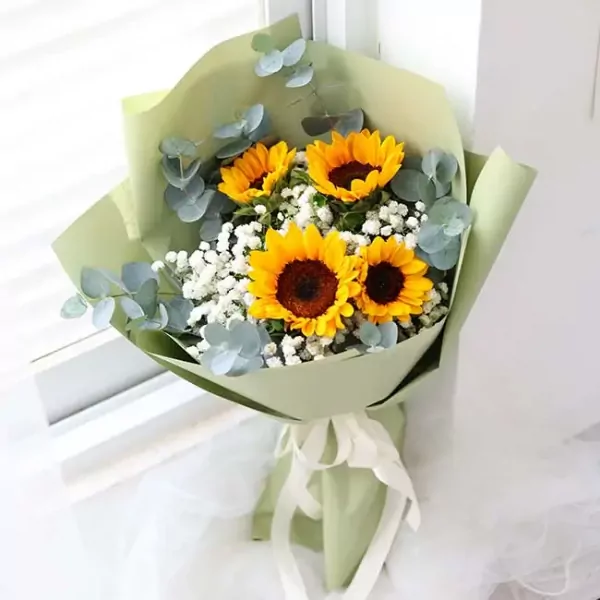 Bouquet of sunflowers, baby's breath, and eucalyptus in green paper.